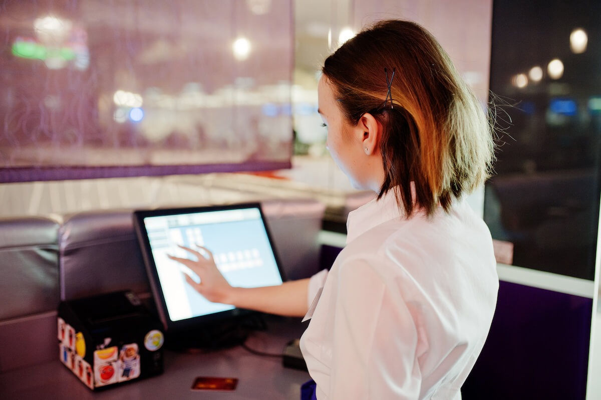 Cashier using a touch screen POS system