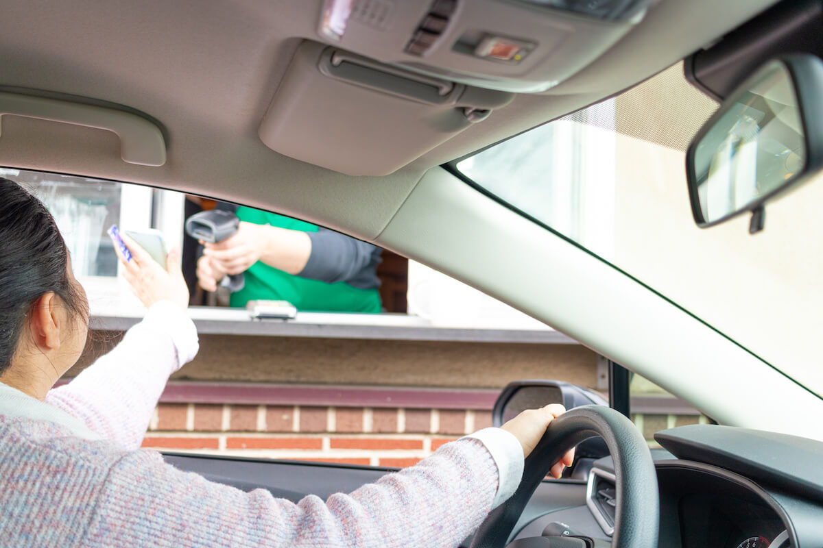 Restaurant drive thru: person paying using a phone