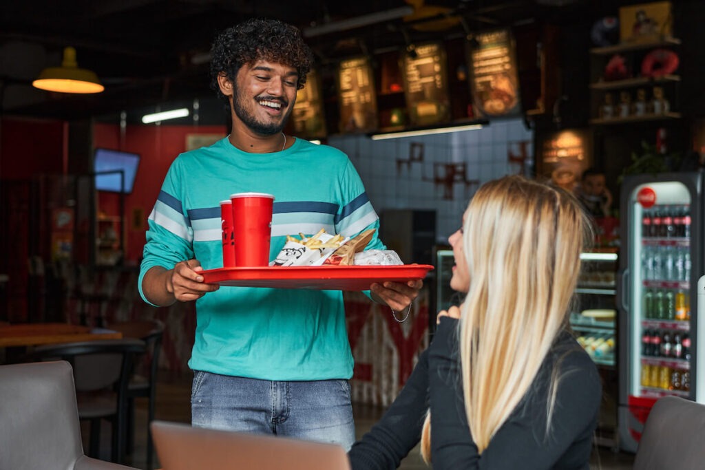 Restaurant AI: man bringing a tray of food to a customer